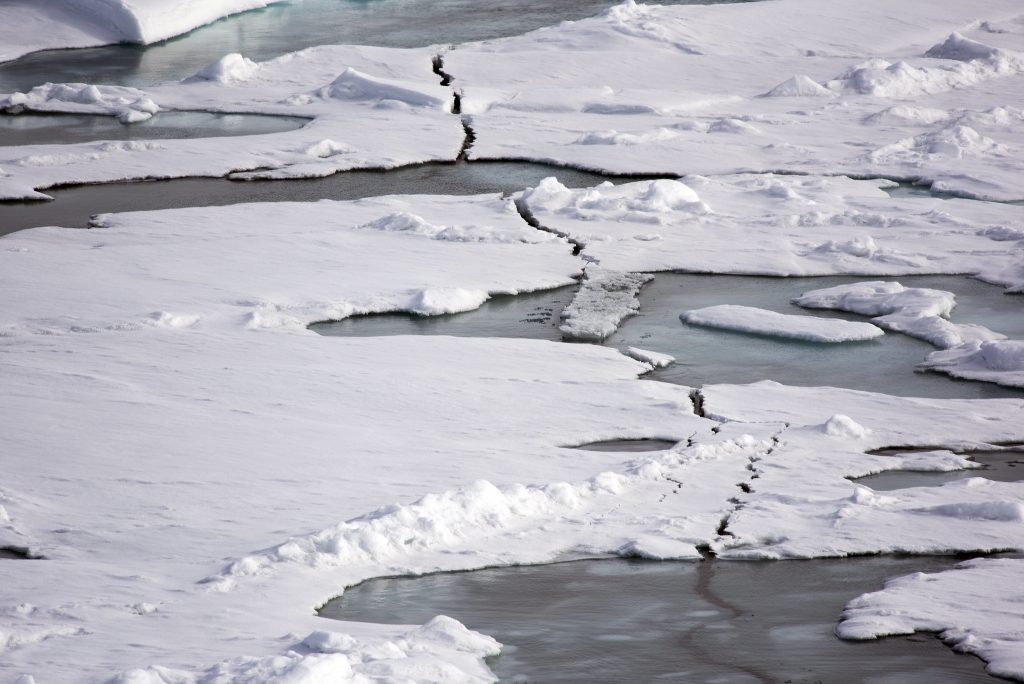 Picture of melting ice sheets in the North with a fissure in the middle. Photograph by Christopher Michel via Flickr. 